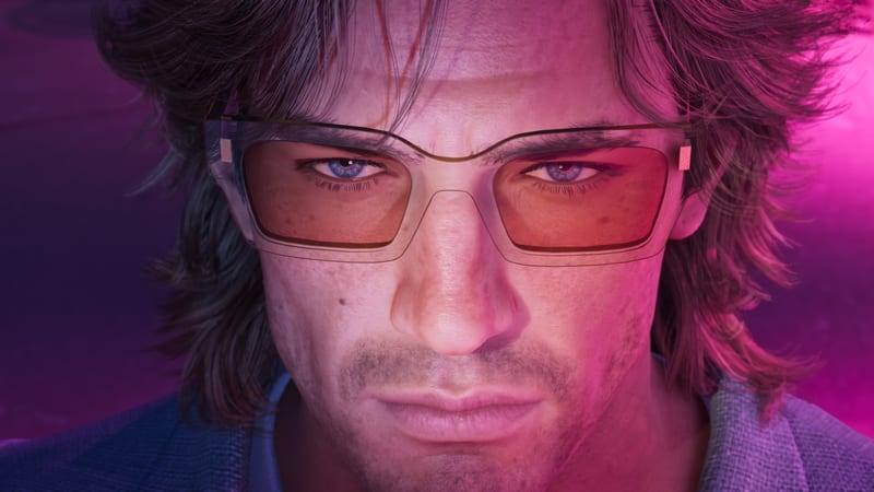 Close-up of Jason Duval, a stubbled man with shaggy hair and orange-tinted glasses, lit in pink and purple.