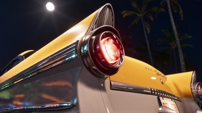 Close-up of the glowing red tail light and chrome fin of a yellow and white '55 Vapid Stanier under a full moon, with palm trees behind.
